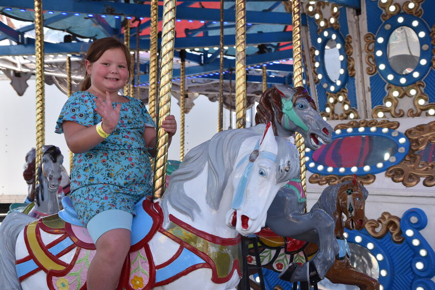 Natalie Wilton at the midway riding the musical horse carousel on August 3.